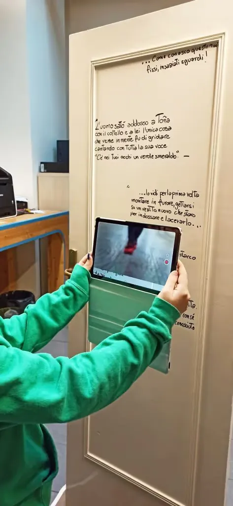 Visitor holding a tablet up to the handwritten side of Pamela Mattana's door to view the AR